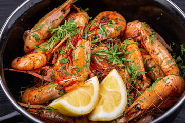 Fried shrimp on oil, served with greens and lemon