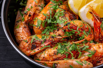 Fried shrimp on oil, served with greens and lemon