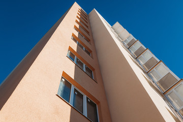 new tall beige multi-story residential building on a sunny day