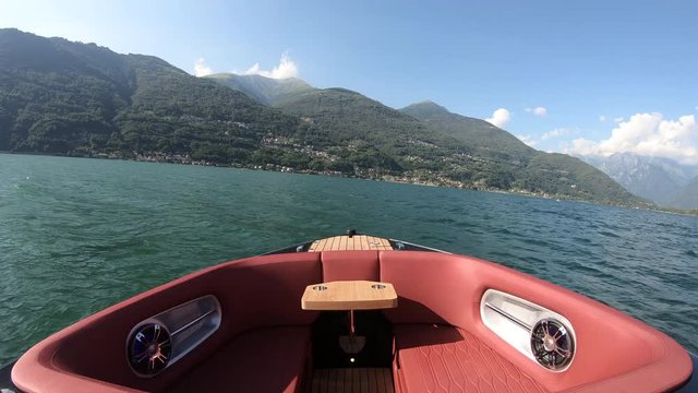 Bow rider boat navigating fast while turning on lake of Lecco, in northern Italy.