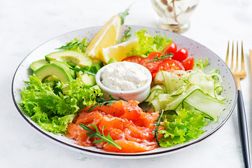 Salad of salted fish salmon, avocado, cherry tomatoes, cucumber, lettuce and cream cheese. Fish menu. Dietary menu. Seafood - salmon.