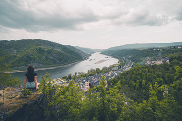 Eine Frau schaut auf die hügelige Landschaft des Rheintals