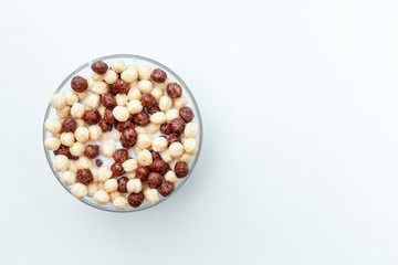 Fototapeta na wymiar Bowl with chocolate corn balls on white background. Cereals. the view from the top