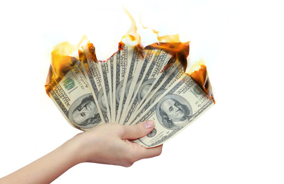 Burning banknotes in a hand. Credit concept