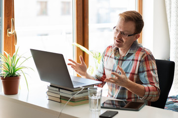 Man on video call on laptop at home