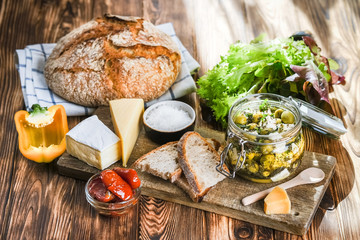 Set of products for a Mediterranean breakfast: olives, bread, cheeses, herbs and vegetables. Healthly food.