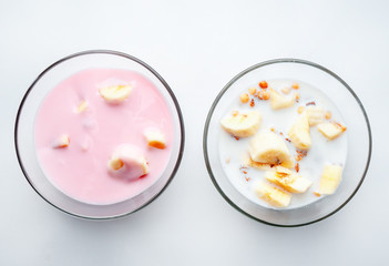 muesli with milk yogurt and banana in plates close-up selective focus. healthy Breakfast, healthy food. on a white background, Breakfast for two