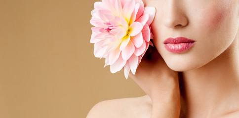 beautiful woman with pink flower. perfect skin. fashion model with flowers. Professional makeup.