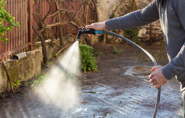 Man watering backyard lawn