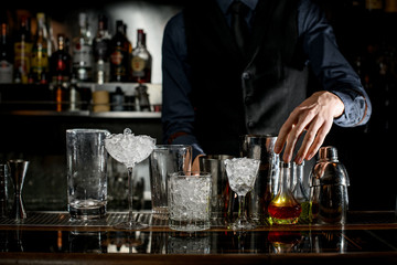 several empty and full glasses and cups stand on bar counter