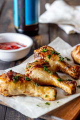 Chicken legs on a wooden background. Barbecue. Grill. American cuisine. Recipe. Rustic.