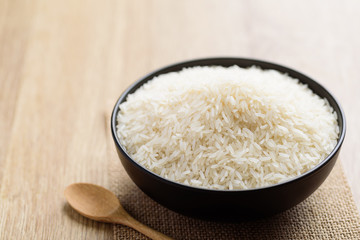 Organic Thai Jasmine rice grain in a bowl and spoon preparing for cooked