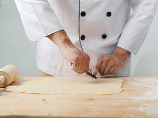 Asian chef preparing dough for pizza or bread on table, work lifestyle