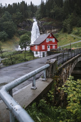 House in Norwegian style, on the background of a waterfall