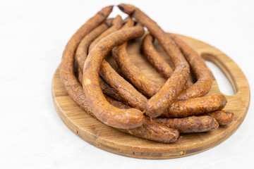 Stack of Smoked sausages on the wooden board