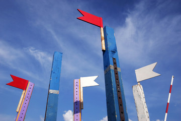 Wooden show jumping barriers with flags on the blue sky background. Colorful barriers for equestrian obstacles.