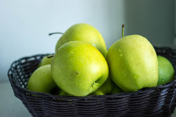 green apples in basket on the table