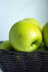green apples in basket on the table