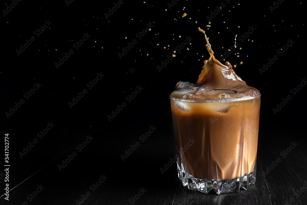 Wall mural Splash of ice coffee drink on a brown background. Cold beverage wave. Close-up design liquor milk, coffee and ice.