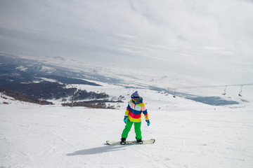 Fototapeta na wymiar Girl snowboarding on the ski slope in Tsakhkadzor (Tsaghkadzor), Kotayk Province, Armenia