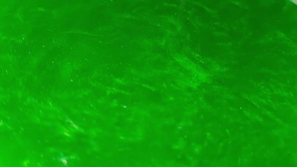 Mixing green shiny dye water. Water current.