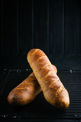 Traditional french baguettes on a dark background top view copy space.