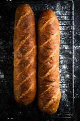 Traditional french baguettes on a dark background top view copy space.