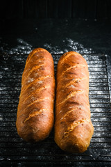 Traditional french baguettes on a dark background top view copy space.