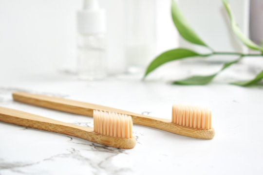 Eco-friendly bamboo toothbrush made.  light gray marble surface, white background. Biodegradable personal care products. No plastic concept. Zero waste.