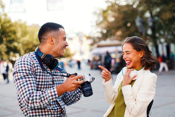 Happy young couple tourists making photos in the city