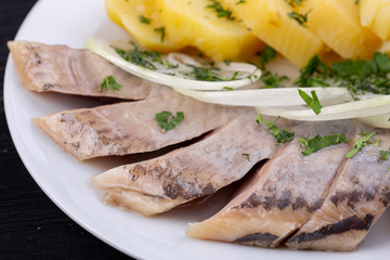 Herring in oil, with cooked potatoes, onions and greens