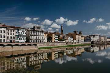 Daytime landscape in Italy, Florence. Photography of houses with reflection in the water.