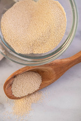 dried and fresh yeast on a white kitchen bacground with wooden rolling pin