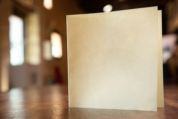 Fototapeta biglietto in bianco su un tavolo in legno isolato su sfocato su  interno di un locale obraz