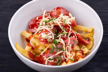 Salad with sausage, grated cheese, potatoes and ketchup with greens