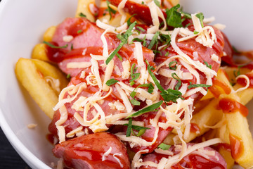 Salad with sausage, grated cheese, potatoes and ketchup with greens