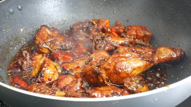 Fried chicken cooked with black soy sauce. The chicken pieces are fried over dry and then poured with soy sauce and onion.