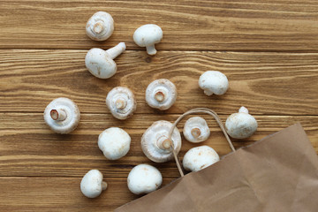 mushrooms spilled out on a wooden table, mushrooms in an eco packet