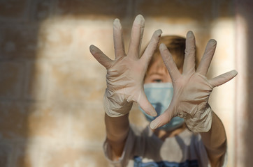 A child with a medical face mask and latex gloves. Protecting the child from Coronavirus and other respiratory diseases. Young children use medical face masks and gloves to protect their health.