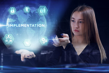 Business, Technology, Internet and network concept. Young businessman working on a virtual screen of the future and sees the inscription: Implementation