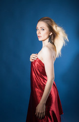 Fototapeta premium beautiful girl with healthy skin and beautiful hair poses in a Studio on a blue background