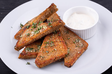 Garlic grens made of black bread, served with greens and cream sauce