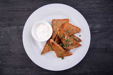 Garlic grens made of black bread, served with greens and cream sauce