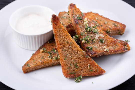 Garlic grens made of black bread, served with greens and cream sauce