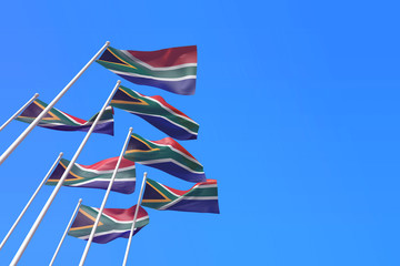 South Africa flags waving in the wind against a blue sky. 3D Rendering