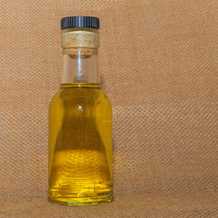 The small bottle of alcohol or sanitizer on the sackcloth baclground. Space for text.