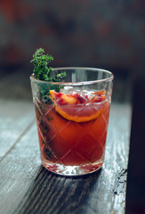 Old-0fashioned cocktail with blood oranges and thyme on the rustic background. Selective focus. Shallow depth of field.