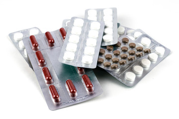 big pile of different pills in blisters on the white background