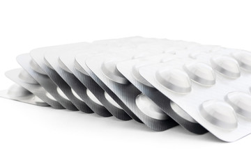 A large stack of tablets in a silver package on a white background, close-up, mock up. Prevention and treatment of diseases, viruses, coronavirus, flu and colds. The idea of medicine and healthcare