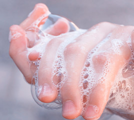 Soap foam on  child hands. Covid - 19 Coronavirus prevention. A child wash our hands with antibacterial soap. Coronavirus  pandemic protection by frequent hand washing. Selective focus